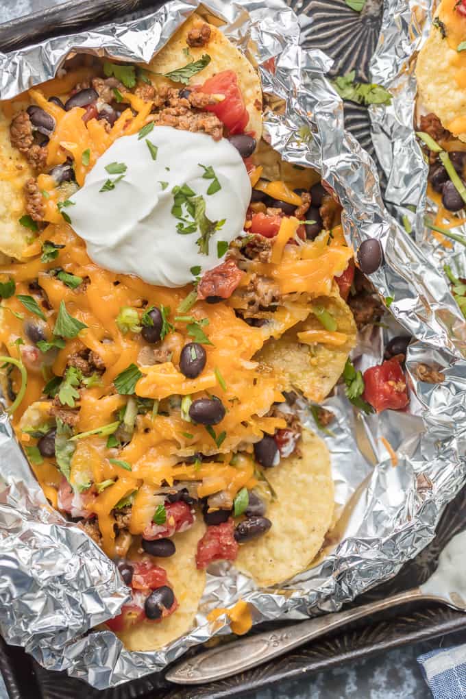 Foil Packet Nachos topped with green chiles and sour cream