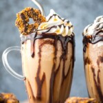 frozen samoa cookie cold brew in a glass topped with a cookie, whipped cream, caramel, and chocolate syrup