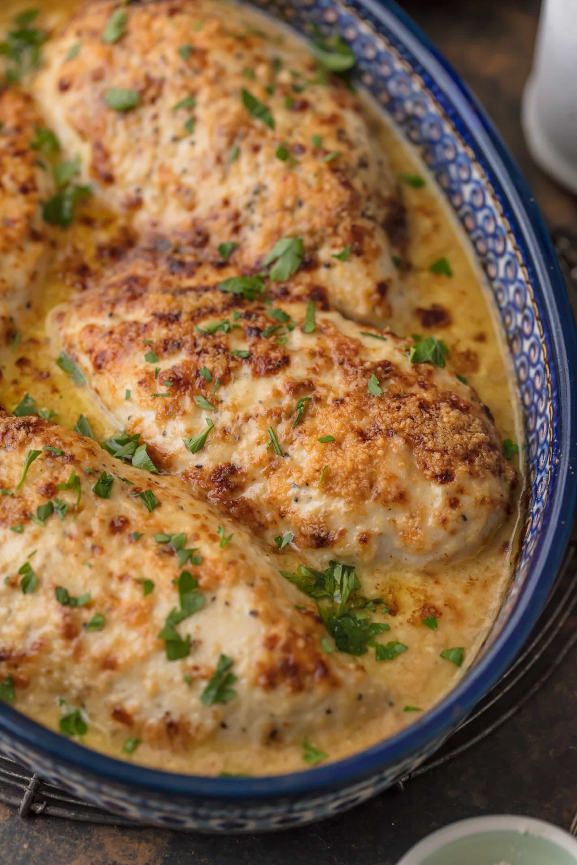 close up on baked chicken breasts in a blue dish