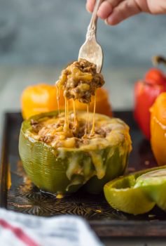 This STUFFED PEPPERS RECIPE is our go-to easy dinner recipe. These Cheesy Enchilada Stuffed Peppers are loaded with beef, green chiles, onions, enchilada sauce, and so much cheese! You won't believe how easy these are and how much your entire family will love them.