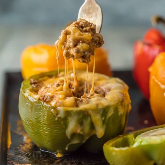 This STUFFED PEPPERS RECIPE is our go-to easy dinner recipe. These Cheesy Enchilada Stuffed Peppers are loaded with beef, green chiles, onions, enchilada sauce, and so much cheese! You won't believe how easy these are and how much your entire family will love them. 