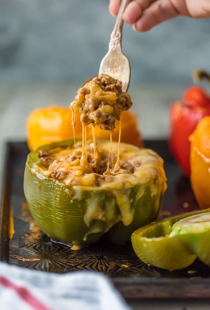 CHEESY ENCHILADA STUFFED PEPPERS are our go-to easy dinner recipe. These bell peppers are stuffed with beef, green chiles, onions, enchilada sauce, and so much cheese!
