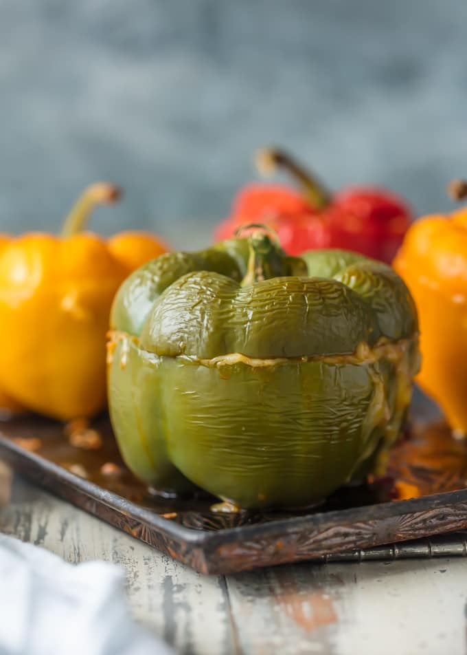 This STUFFED PEPPERS RECIPE is our go-to easy dinner recipe. These Cheesy Enchilada Stuffed Peppers are loaded with beef, green chiles, onions, enchilada sauce, and so much cheese! You won't believe how easy this stuffed bell pepper recipe is and how much your entire family will love it. cheesy stuffed peppers on sheet pan