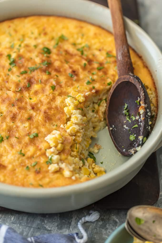 Wood spoon sitting in a dish of corn pudding