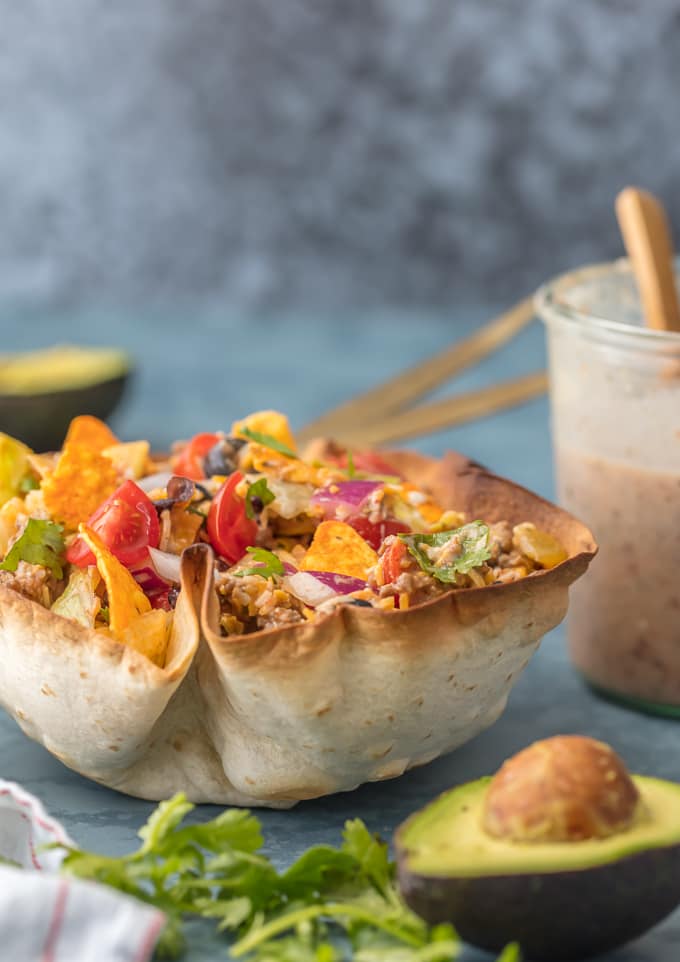 Taco salad bowl filled with ground beef, lettuce, tomatoes