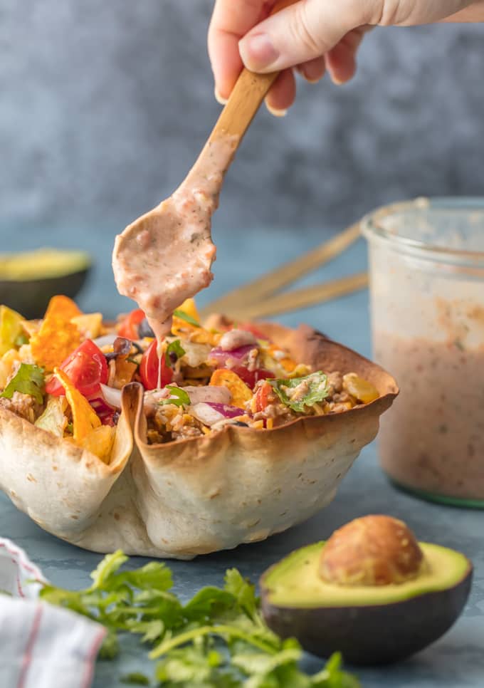 Taco Bowl being topped with creamy ranch salsa dressing