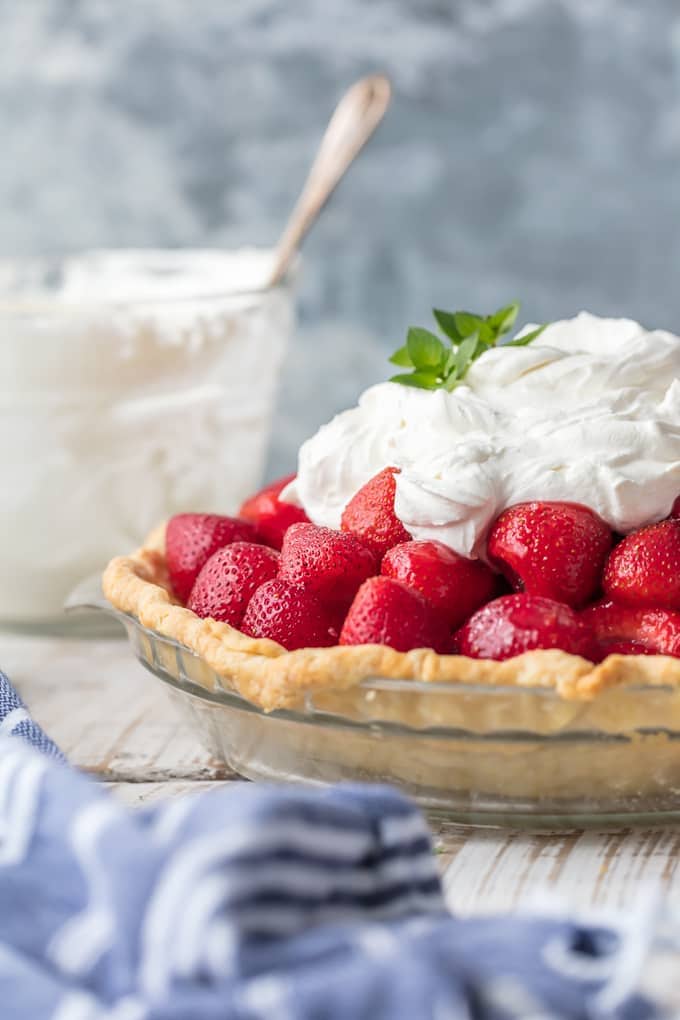 strawberry pie topped with whipped cream on a table