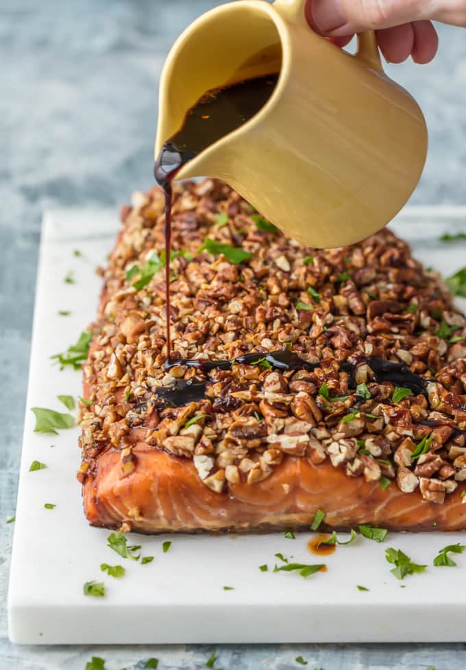 Honey Bourbon glaze being poured over Pecan Crusted Salmon 