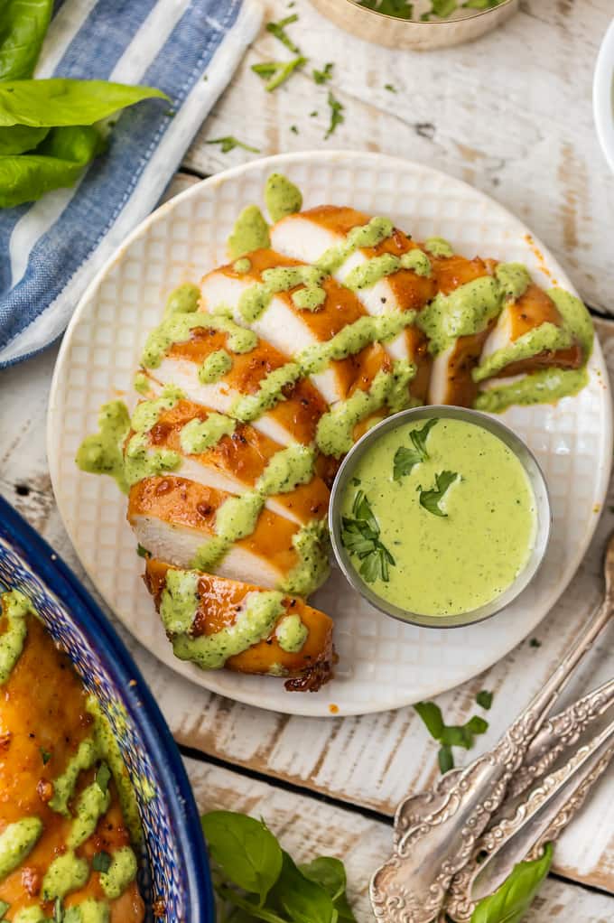 Sliced chicken on plate with green sauce