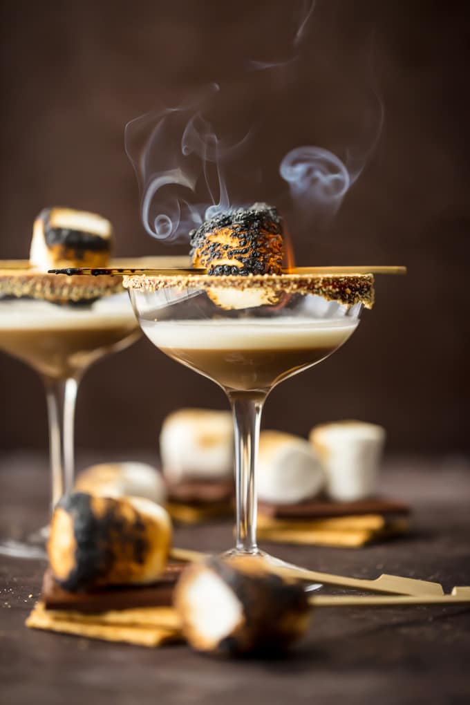 This TOASTED S'MORE MARTINI is as succulent as it is beautiful. With layers of cream, marshmallow vodka, and chocolate liqueur all you need is a graham cracker rim! So fun and festive for Fall. Cocktail photography cookbook photography