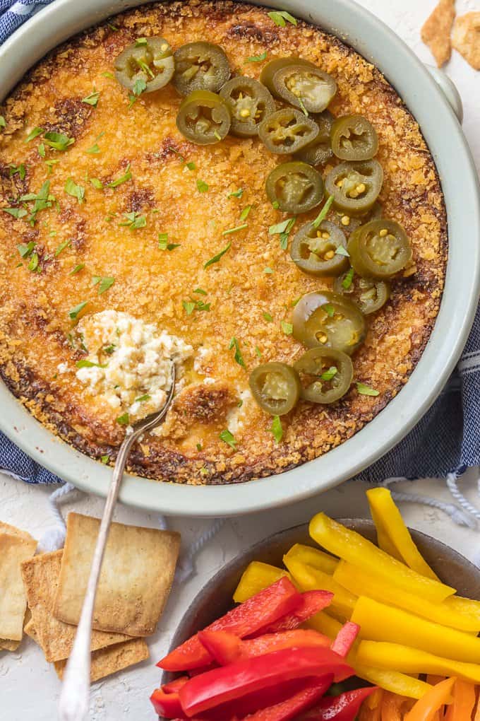 Jalapeno Popper Dip is the perfect hot dip recipe to serve on game day! It's a little bit spicy, a little bit creamy, and a whole lot of flavor. It just doesn't get better than this Hot Jalapeno Popper Dip Recipe. We especially love this dip for tailgating! Jalapeno Popper Dip in a large serving dish