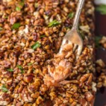 a fork pulling up pecan crusted honey bourbon salmon