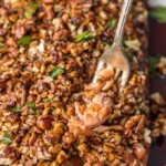 a fork pulling up pecan crusted honey bourbon salmon
