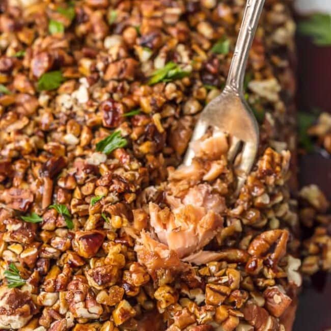 a fork pulling up pecan crusted honey bourbon salmon