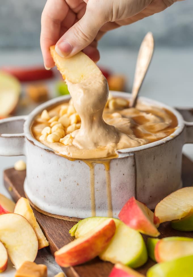 apple being dipped into caramel apple dip