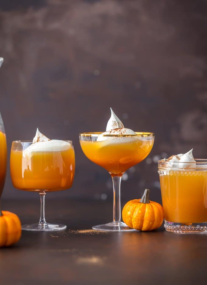 This Pumpkin Punch recipe is the perfect Thanksgiving or Halloween Punch idea. A fun & tasty Pumpkin Cocktail inspired by pumpkin pie! Glasses of pumpkin cocktails topped with whipped cream