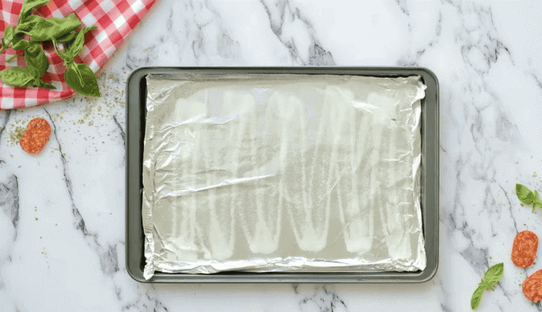 Baking sheet lined with sprayed aluminum foil.
