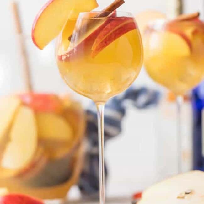 Apple Pie Sangria glass on a table with apples