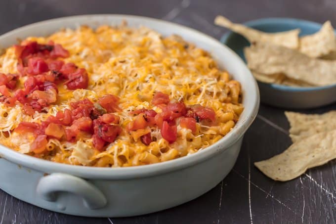 Casserole dish filled with macaroni, velveeta, tomatoes, chicken, and more