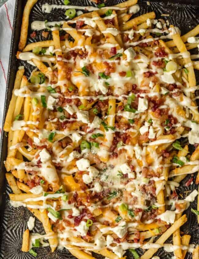Nothing makes game day delicious more than 3 CHEESE BACON RANCH FRIES. This easy and fun appetizer takes crispy fries and tops them with ranch seasoning, bacon, cheddar, mozzarella, and feta.
