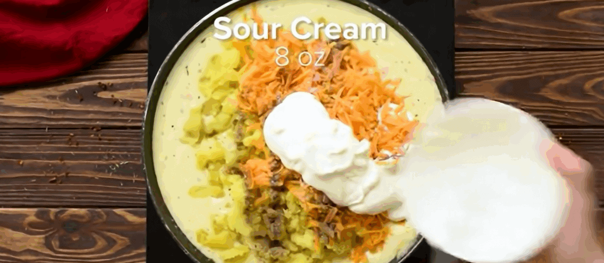 Adding potatoes, cheese, and sour cream to the soup pot.  - 10