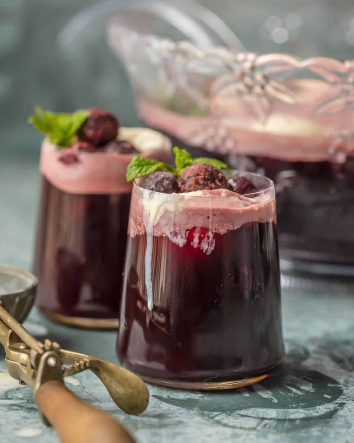 This PARTY PUNCH RECIPE is a sweet and tasty treat because it's filled with ice cream! This Cherry Vanilla Ice Cream Punch is the perfect party punch and feels really festive. It only has 4 ingredients and it's an instant hit at any holiday get together. This Easy Party Punch is the ultimate Christmas drink recipe. Two glasses of party punch.