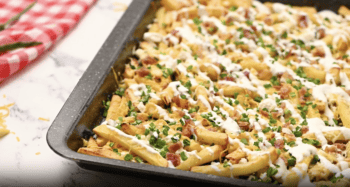 Cheesy bacon cheese fries in a baking pan.