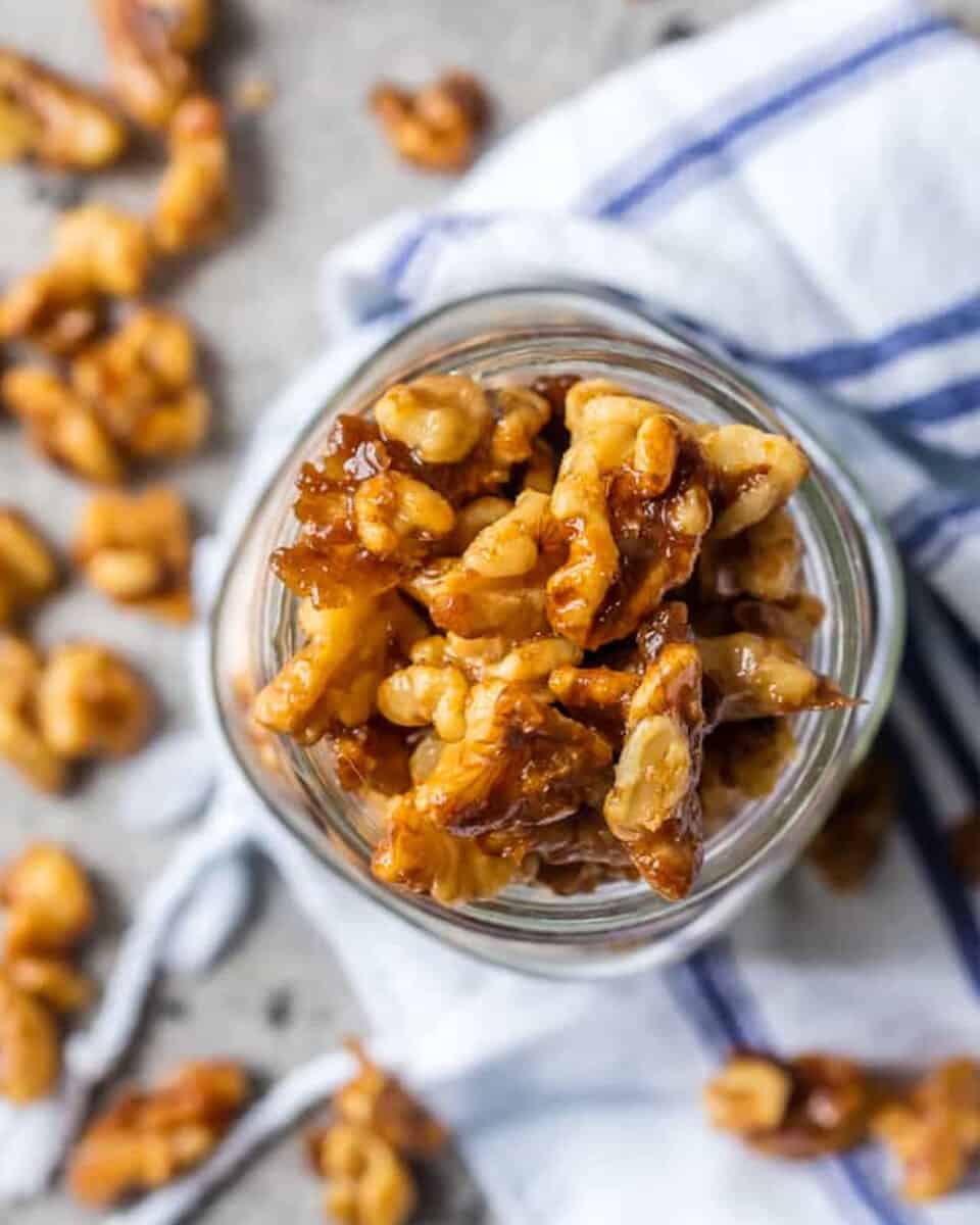 Candied walnuts in a jar on a table.