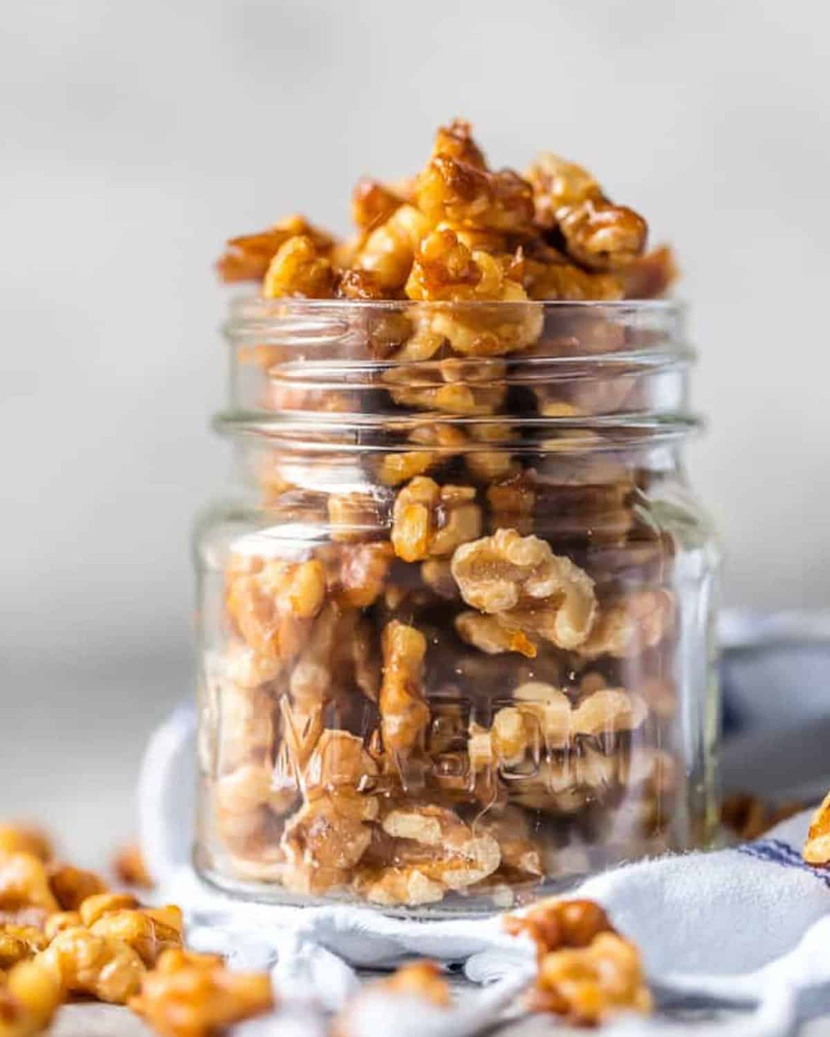 Walnuts in a glass jar with a spoon - candied walnuts.