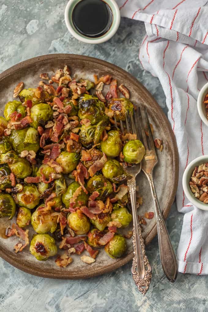top view of a plate with forks and Balsamic Brussels Sprouts with Bacon and Pecans