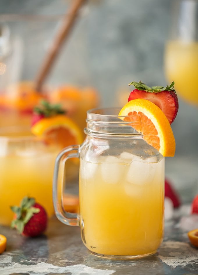 mason jar of sangria garnished with strawberries and sliced oranges