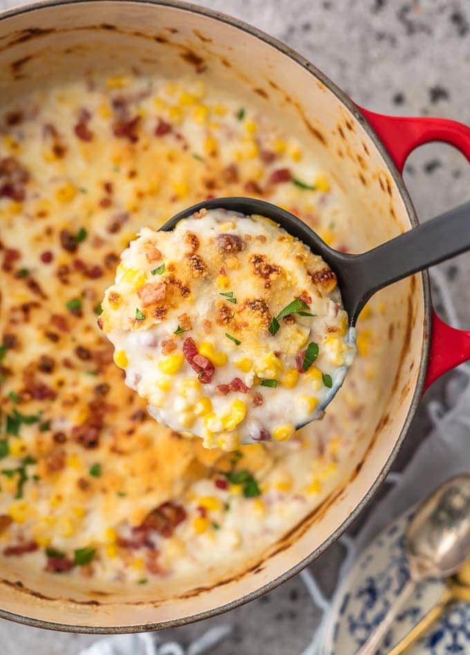 Red pot full of creamed corn recipe with bacon, parmesan, & mascarpone
