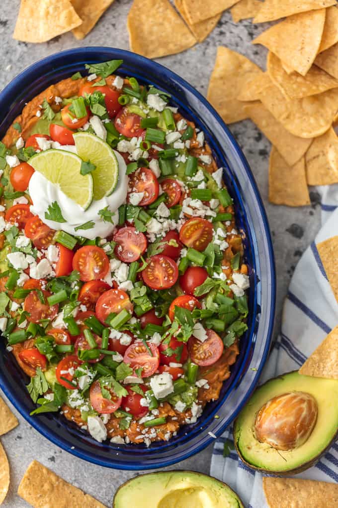 Large serving dish filled with layered guacamole bean dip