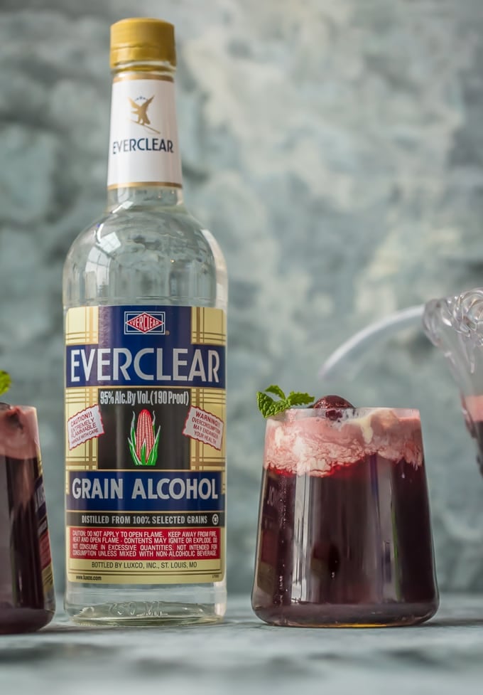 Cherry Vanilla Party Punch in a glass next to a bottle of Everclear