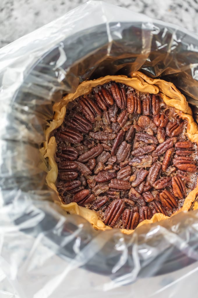 This SLOW COOKER PECAN PIE will knock your socks off and make for a delicious and easy Thanksgiving, Christmas, or Easter! We LOVE Pecan Pie and it's just as delicious made in a crockpot!