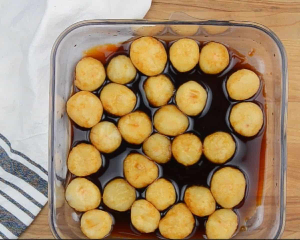 Whole water chestnuts marinating in soy sauce.