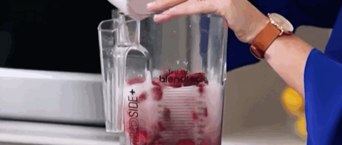 Blending strawberries and soda in a blender. 
