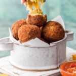 These Arancini Balls with Cheese Bacon and Broccoli are so much easier than you might think. This Arancini Recipe is one of our favorite comfort food appetizers! These cheesy fried rice balls (Arancini Balls) are the ultimate starter to any meal at home. So addicting and delicious!