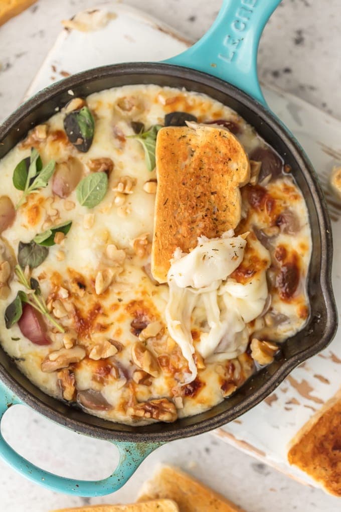 Provolone cheese dip in skillet with walnuts on top