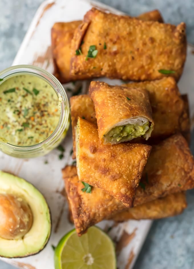 Easy egg rolls recipe, egg rolls stacked up next to bowl of guacamole