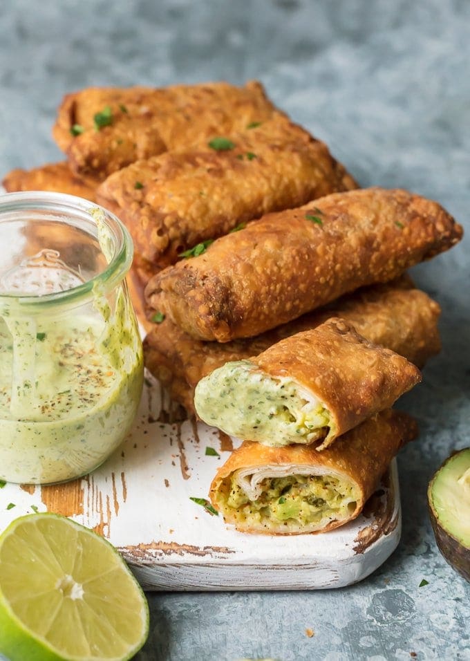 Pile of egg rolls on white serving board