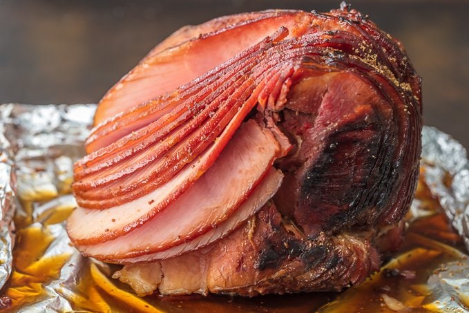 spiral cut honey baked ham on a foil lined baking pan