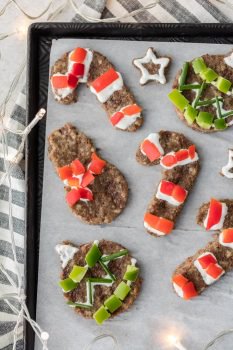 sheet pan of Sausage "cookies" - breakfast sausage shaped with cookie cutters and decorated with red and green peppers