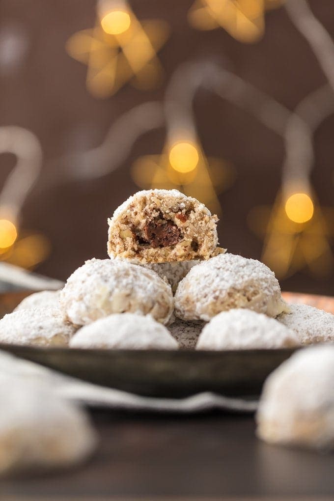 plate of NUTELLA STUFFED SNOWBALL COOKIES with a bite taken out of one of them