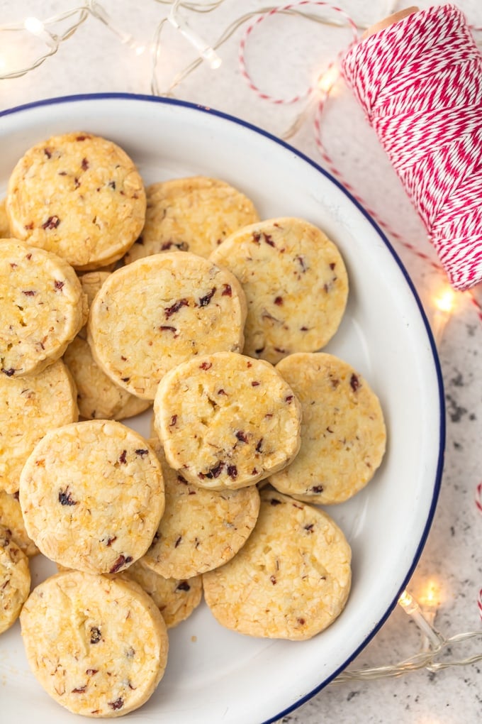 Orange and cranberry shortbread cookies on a white plate
