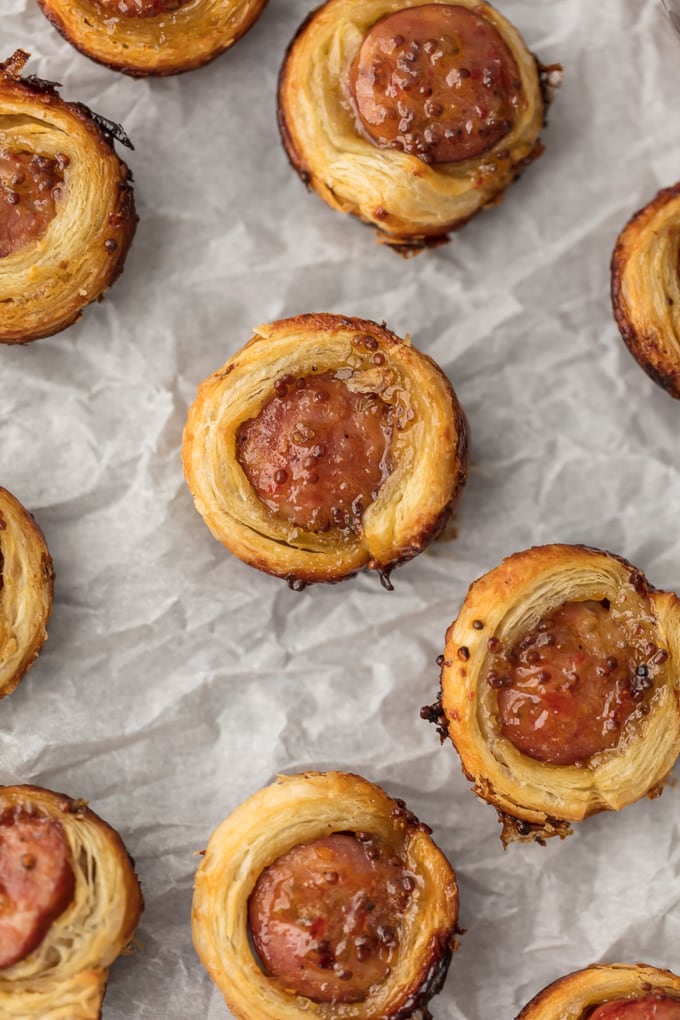 bite sized appetizers called PEPPER JELLY SAUSAGE ROLLS on a piece of white baking parchment paper