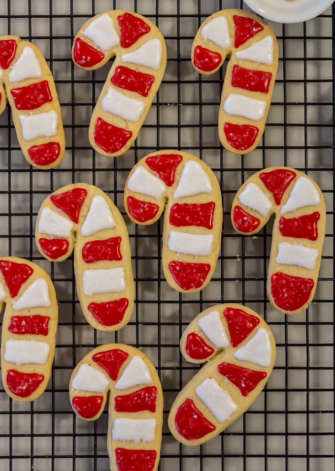 Christmas Sugar Cookies: red and white striped candy cane shaped sugar cookies on a cooling rack