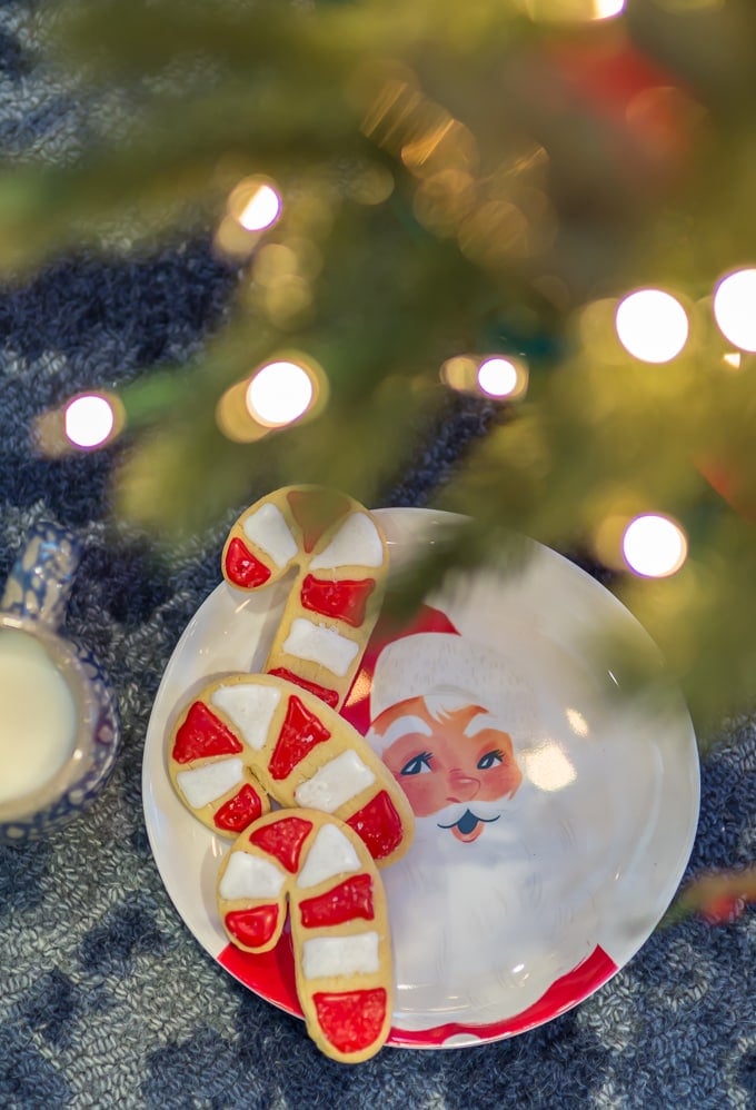 Christmas Sugar Cookies: candy cane shaped sugar cookies on a plate under the Christmas tree