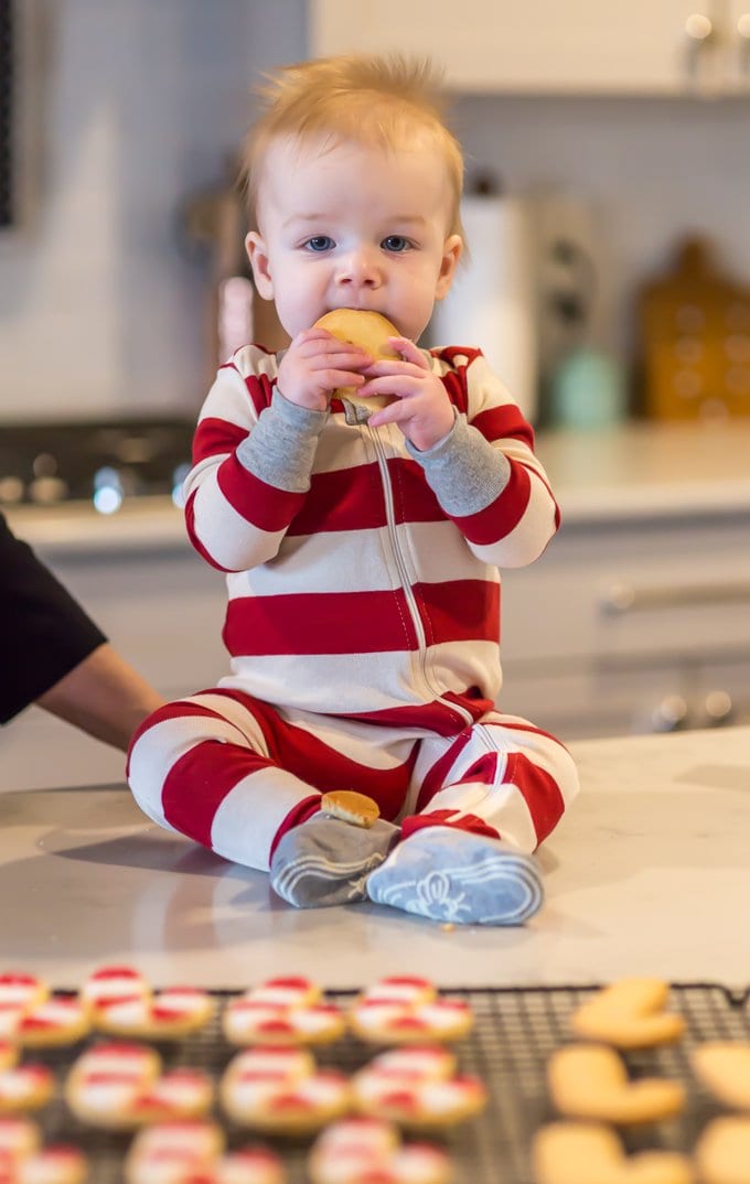 Baby in red and white striped onesie, eating the best sugar cookies