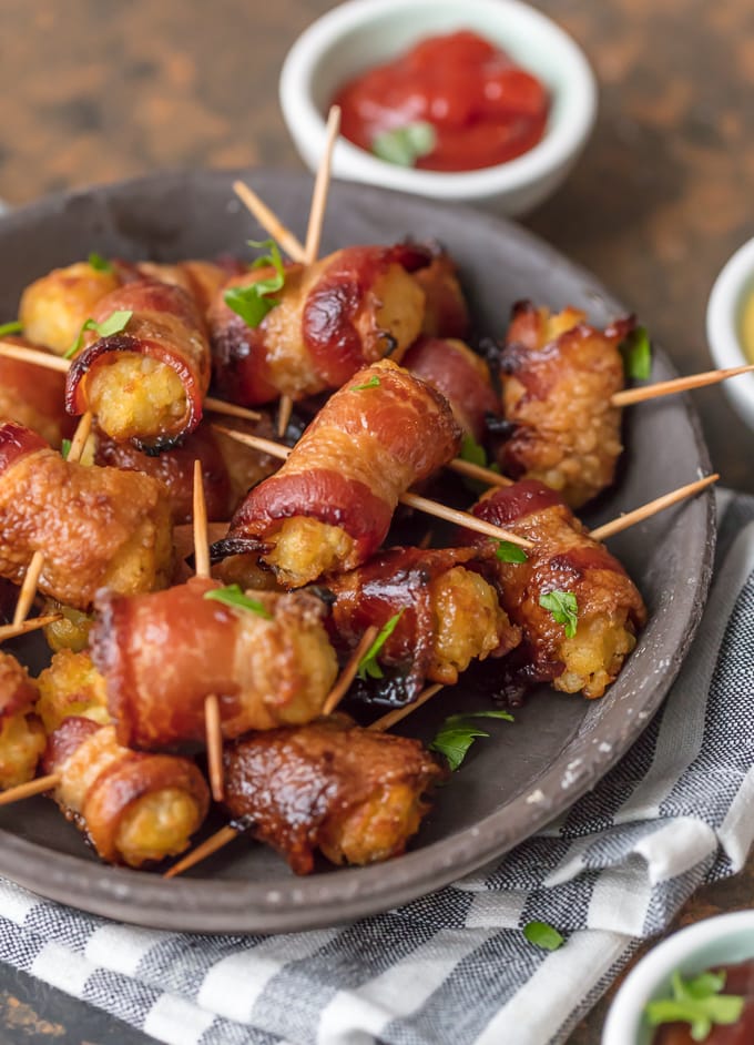tater tots wrapped in bacon on a plate